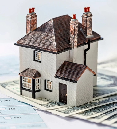 miniature house with a paper bill underneath